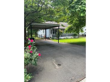 Charming home featuring a covered carport and cozy front porch, surrounded by lush greenery at 167 Mathews Se Cir, Marietta, GA 30067