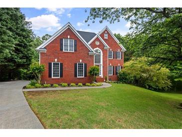 Beautiful brick home with black shutters, green lawn, and well-manicured landscaping at 3014 Volland Grove Trail, Lawrenceville, GA 30043