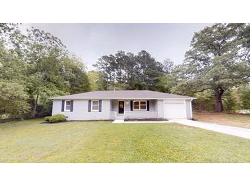 Charming single-story home with gray paint, complemented by a lush green lawn at 7125 Puckett Sw St, Covington, GA 30014