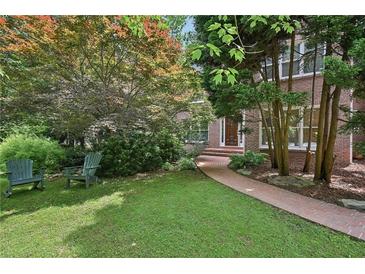 Charming brick home with a lush front yard, walkway, and inviting rocking chairs at 1243 Williamswood Pointe, Decatur, GA 30033