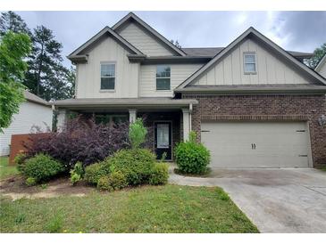 Inviting two-story home with brick and siding, showcasing a well-maintained lawn and attached two-car garage at 2289 Overlook Ave, Lithonia, GA 30058