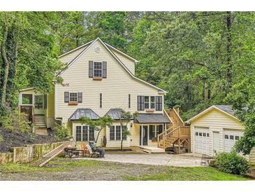 Charming two-story home with a lush green backdrop, a detached garage, and inviting front yard space at 510 Aiken Dr, Dallas, GA 30157