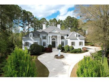 Elegant two-story home with a circular driveway, landscaped yard and a classic columned facade at 5360 Northwater Way, Duluth, GA 30097
