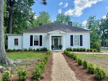Charming home featuring a gravel path, lush landscaping, and black shutters against a white exterior at 95 Whitlock Sw Ave, Marietta, GA 30064