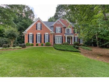 Charming brick home features a manicured lawn, black shutters, and lush landscaping at 5010 Bonnie Way, Roswell, GA 30075