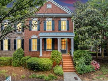 Charming two-story brick home with manicured landscaping and a welcoming front porch and entry at 5000 Davenport Pl, Roswell, GA 30075
