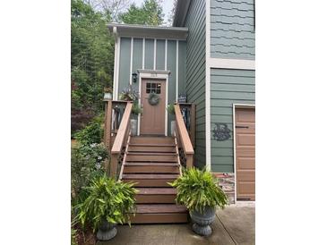 Inviting front entrance with wooden steps and potted ferns leading to a charming, light-filled home at 313 India Ln, Canton, GA 30114