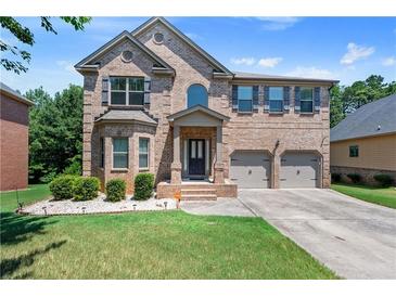 Charming two-story brick home featuring manicured lawn and two-car garage at 65 Waters Edge Ln, Covington, GA 30014