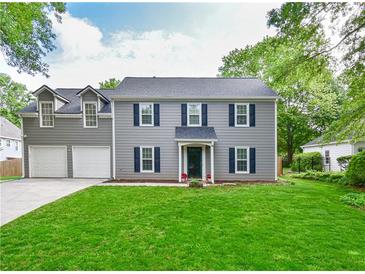 Charming two-story home with grey siding, dark shutters, manicured lawn and an attached two car garage at 3171 Davis Rd, Marietta, GA 30062