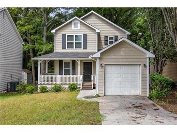 Charming two-story home with a covered front porch and a one car attached garage at 429 Orchard Dr, Stone Mountain, GA 30083