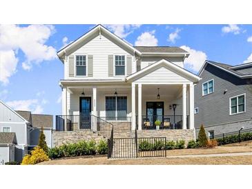 Charming two-story home featuring a welcoming front porch, stone accents, and professionally landscaped yard at 2005 Haley Walk, Woodstock, GA 30188