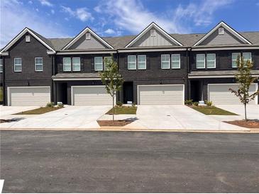 New townhomes feature brick facades, a garage for each unit and well-manicured landscaping at 216 Eping Dr, Stockbridge, GA 30281