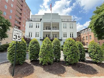 Beautiful condominium building with well-manicured landscaping and an American flag at 3655 Peachtree Ne Rd # 304, Atlanta, GA 30319