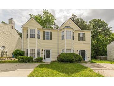 Charming two-story home with yellow siding, a well-maintained yard, and an inviting front entrance at 5680 Hampton Ct, Atlanta, GA 30349