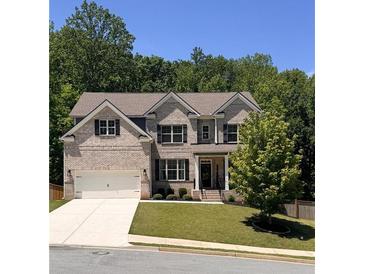Beautiful two-story brick home with a manicured front lawn, attached two-car garage, and mature trees at 4736 Landing Water Path, Buford, GA 30519