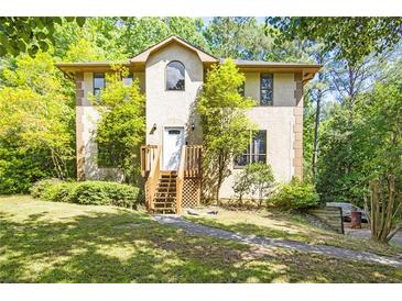 Inviting exterior featuring a stucco facade, wooden stairs leading to the front door, and lush landscaping at 1105 Mitchell Crossing Sw Dr, Atlanta, GA 30331