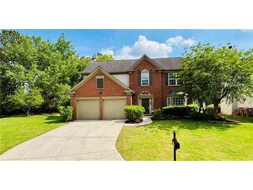 Beautiful two-story brick home featuring an attached two-car garage and a well-manicured front yard at 655 Wellingborough Ct, Alpharetta, GA 30005