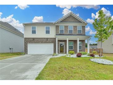 Charming two-story home featuring a brick facade and a well-maintained lawn, perfect for Gathering living at 1603 Maston Rd, Auburn, GA 30011