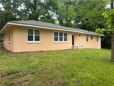 Low angle of a single story home with an orange exterior and many rectangular windows at 2076 Garden Cir, Decatur, GA 30032
