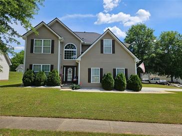 Inviting two-story home with manicured lawn and charming curb appeal under a beautiful sky at 4279 Persian Ct, Snellville, GA 30039