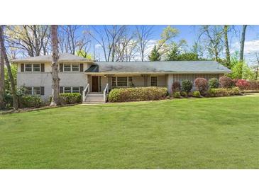 Charming two-story home with a well-manicured front lawn and landscaped bushes and shrubbery at 1436 Diamond Head Drive Dr, Decatur, GA 30033