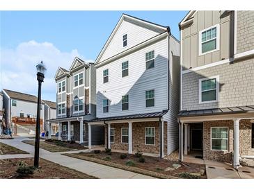 New three-story townhomes featuring a combination of lap siding and stone accents at 2111 Wesson Ct, Kennesaw, GA 30144