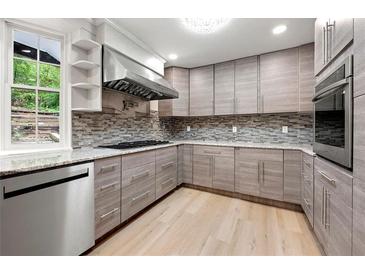 Bright kitchen featuring stainless steel appliances, wood-look cabinets, and granite countertops at 2828 Cloverhurst Dr, Atlanta, GA 30344