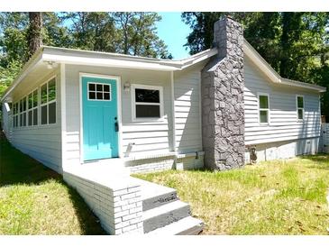 Charming home with a vibrant blue door, stone chimney and well-manicured lawn at 2346 Pryor Sw Rd, Atlanta, GA 30315