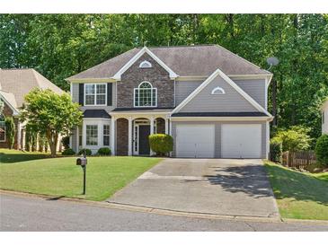 Charming two-story home featuring a stone accent facade, two-car garage, and a well-manicured lawn at 3798 Kirkwood Nw Run, Kennesaw, GA 30144