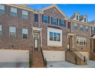 Charming brick townhome featuring a garage and steps leading to the front door with a classic and welcoming facade at 4206 Townsend Ln, Atlanta, GA 30346