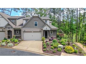 Charming townhome with a two-car garage and beautifully landscaped front yard at 232 Heron Pointe Vw, Canton, GA 30114