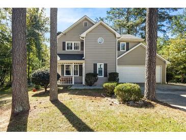 Inviting two-story home featuring neutral siding, dark shutters, and a well-maintained front yard at 1493 Martin Nash Sw Rd, Lilburn, GA 30047
