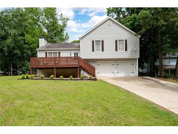 Charming two-story home with a well-maintained lawn, a wooden deck, and a two-car garage at 701 Rockingham Ct, Woodstock, GA 30189