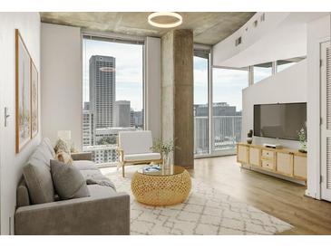 Bright living room featuring hardwood floors, large windows, and a comfortable seating area, perfect for relaxing and entertaining at 860 Peachtree Ne St # 2209, Atlanta, GA 30308