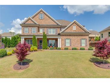 Beautiful brick home with well-manicured lawn, landscaping, symmetrical design and inviting covered entryway at 1074 Nash Springs Cir, Lilburn, GA 30047