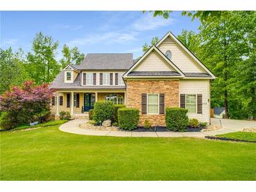 Charming two-story home with stone accents, manicured lawn and mature trees at 374 Beaumont Farms Dr, Sharpsburg, GA 30277