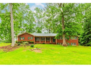 Charming brick ranch-style home with green shutters and a covered front porch on a spacious lot at 201 Smithstone Path, Fayetteville, GA 30214