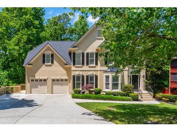 Beautiful two-story home boasts manicured landscaping, a two-car garage, and mature trees at 12350 Stevens Creek Dr, Alpharetta, GA 30005