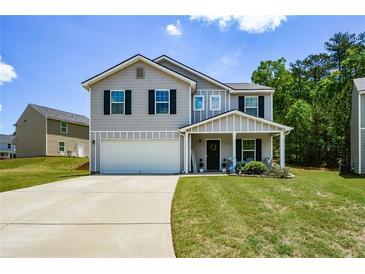 Charming two-story home with a covered front porch, attached garage and well-manicured lawn at 354 Jada Ln, Villa Rica, GA 30180