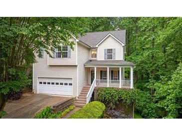 Charming two-story home with a well-manicured lawn, an attached garage, and a welcoming front porch at 3370 Ashton Dr, Suwanee, GA 30024