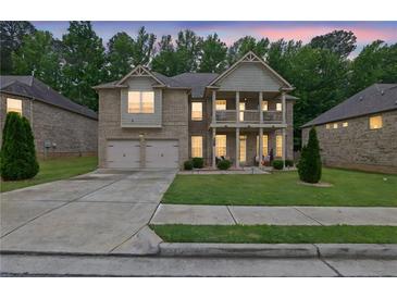 Charming two-story home boasts a double garage, landscaped yard, and a covered front porch at 412 Live Oak Pass, Loganville, GA 30052