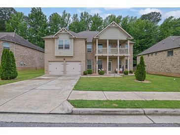 Charming two-story brick home featuring a double-door garage and welcoming front porch and upstairs balcony at 412 Live Oak Pass, Loganville, GA 30052
