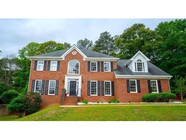 Beautiful two-story brick home features a manicured lawn, black shutters, and a classic front entrance at 1200 Larson Sw Ln, Marietta, GA 30064