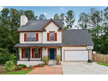 Charming two-story home with red shutters, covered porch, brick walkway, and attached two-car garage at 3055 Kennesaw Nw Dr, Kennesaw, GA 30152