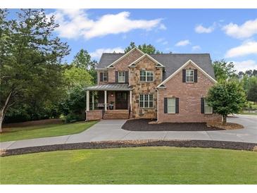 Beautiful two-story brick home with manicured lawn and stone accents on a sunny day at 18 Starlight Dr, Cartersville, GA 30121