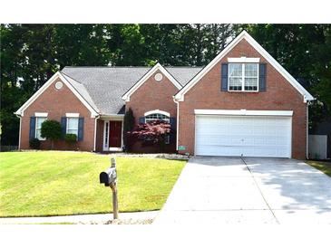 Charming brick home with well-manicured lawn, two-car garage, and inviting front entrance at 1162 Apalachee Run Trl, Dacula, GA 30019