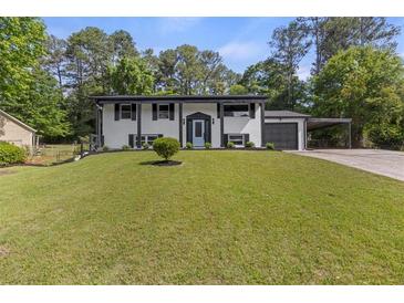 Charming two-story home with black and white accents and a well-manicured lawn at 1253 Willow Dr, Riverdale, GA 30296