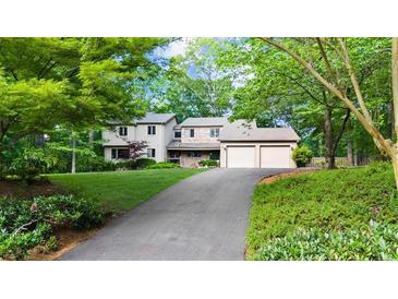 Charming two-story home with a well-maintained lawn and a two-car garage at 1665 Chevron Way, Sandy Springs, GA 30350