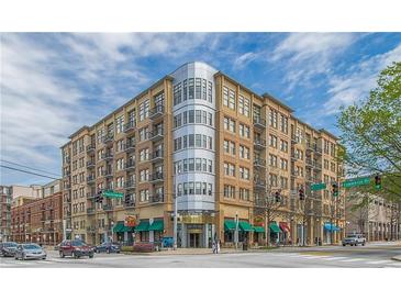 Tan brick condo building featuring a corner glass facade, private balconies, and street-level retail at 201 W Ponce De Leon Ave # 515, Decatur, GA 30030