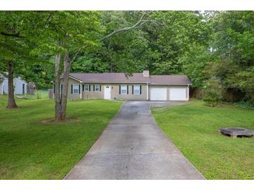 Traditional home featuring a two-car garage, and a long driveway at 103 Sir Gregory Nw Mnr, Lawrenceville, GA 30044